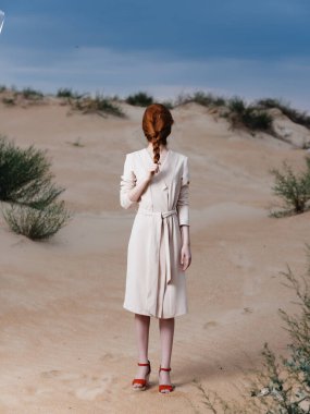 Kumsalda beyaz önlüklü bir kadın temiz hava veriyor.