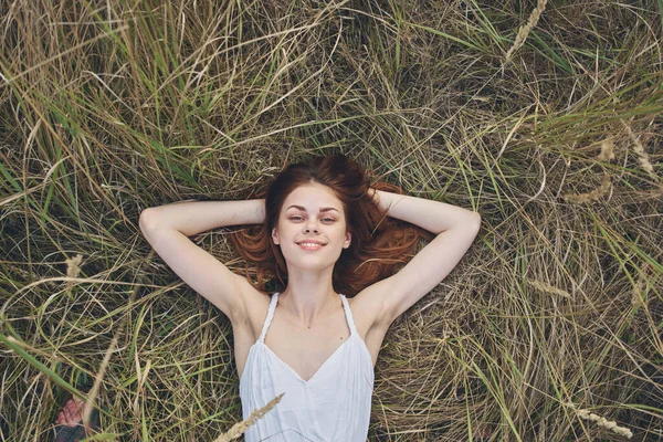 Güzel, neşeli bir kadın yaz tatilinde çimlerde yatıyor. — Stok fotoğraf