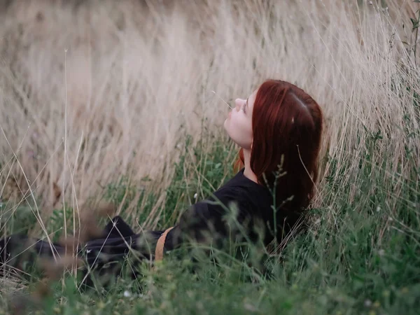 옷차림을 하고 있는 여자는 풀밭의 자연의 자유 위에 놓여 있다 — 스톡 사진