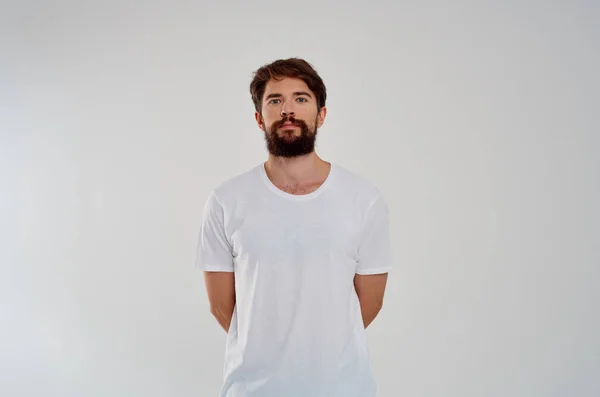 Carino uomo barbuto in bianco t-shirt studio di moda sfondo leggero — Foto Stock