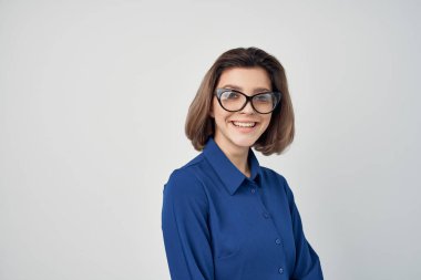 Gözlüklü kadın mavi gömlekleri açık arkaplan pozu