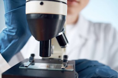 Masa mikroskobunda oturan laboratuvar asistanı biyoteknoloji araştırma ışık arka planı