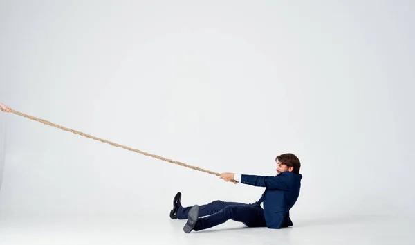 Business man in a suit pulls the rope emotions studio — Stock Photo, Image