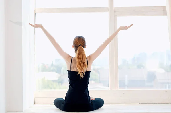 Kadın pencere kenarında egzersiz yaparken meditasyon yapıyor. — Stok fotoğraf