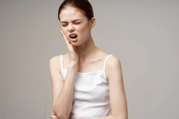Γυναίκα σε λευκό t-shirt πονόδοντο προβλήματα υγείας διαταραχή στούντιο θεραπεία — Φωτογραφία Αρχείου