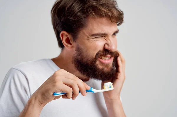 Muž zubní kartáček v hygieně rukou čisté zuby světlo pozadí — Stock fotografie