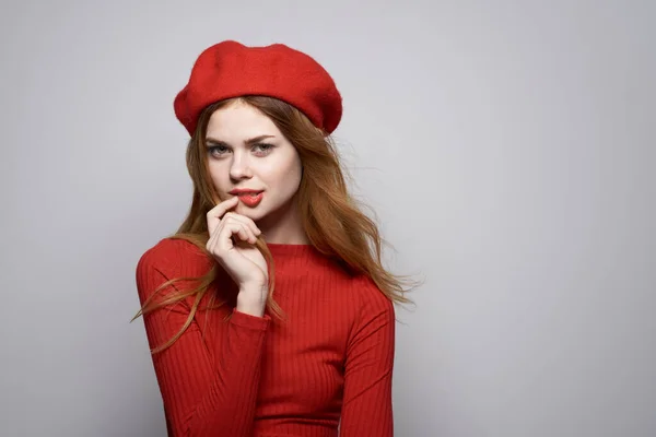 Mujer alegre con una gorra roja en la cabeza glamour fondo claro —  Fotos de Stock