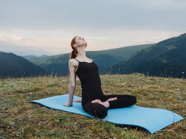 Dağlardaki sportif kadın dışarıda yoga egzersizi yapıyor. — Stok fotoğraf