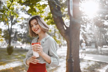 Güzel bir kadın çekici görünüyor. Kırmızı dudaklar parkta yürüyor. Temiz hava.