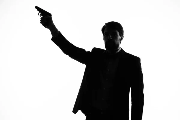 The man in a suit with a pistol in hand crime hand gesture light background — Stock Photo, Image