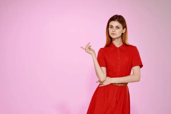 Mulher de cabelos vermelhos em vestido vermelho moda estilo elegante fundo rosa — Fotografia de Stock