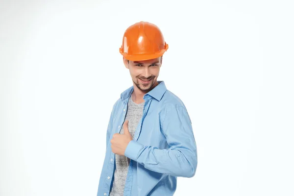 Homem em laranja chapéu duro construção segurança trabalho luz fundo — Fotografia de Stock