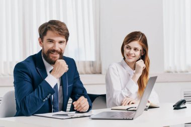 İş adamı ve kadın dizüstü bilgisayarın önünde konuşuyor.