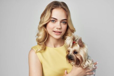 Sarı elbiseli güzel bir kadın. Eğlenceli. Küçük bir köpek izole edilmiş.