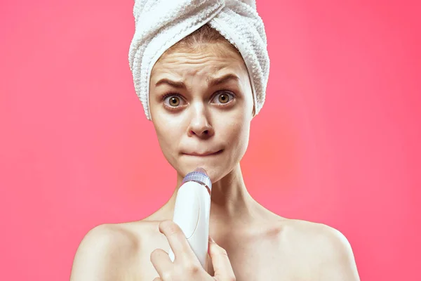 Mulher com toalha na cabeça limpeza rosto cuidados da pele rosa fundo — Fotografia de Stock