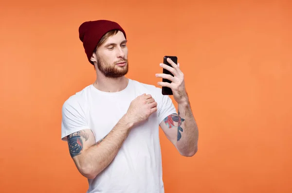 Man met een telefoon in zijn handen modieuze hoed poseren Studio — Stockfoto
