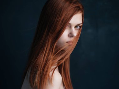 Çekici kızıl saçlı, çıplak omuzlu, açık tenli, koyu tenli bir kadın.