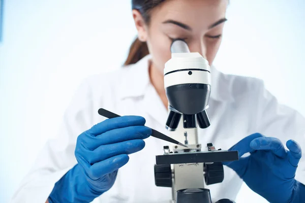 Γυναίκα βοηθός εργαστηρίου κοιτάζοντας μέσα από ένα μικροσκόπιο της τεχνολογίας της επιστήμης — Φωτογραφία Αρχείου