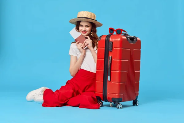 Mooie vrouw toerist dragen hoed rood koffer vakantie blauw achtergrond — Stockfoto