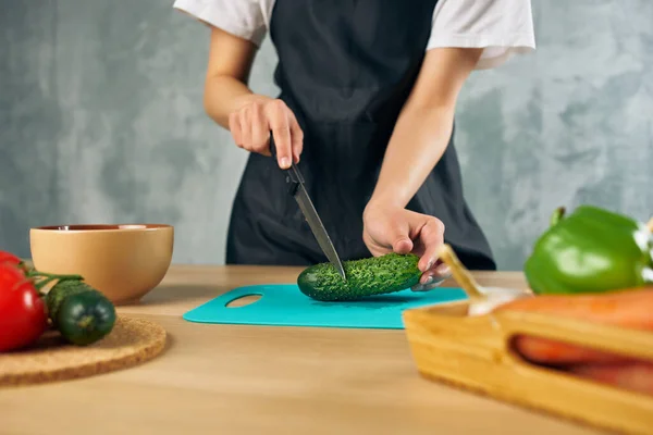 Femme au foyer sur la cuisine coupe légumes planche à découper — Photo