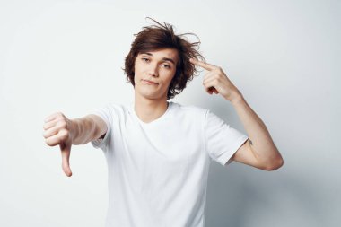 Yüzünde sivilce olan beyaz tişörtlü bir adam sağlık sorunları yaşıyor.