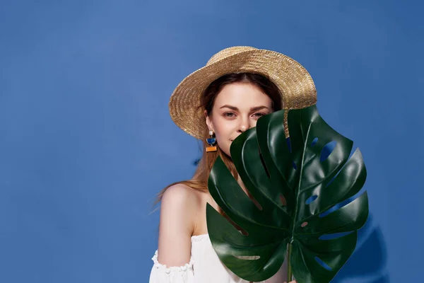 Attraktiv kvinna grön palm blad poserar blå bakgrund — Stockfoto