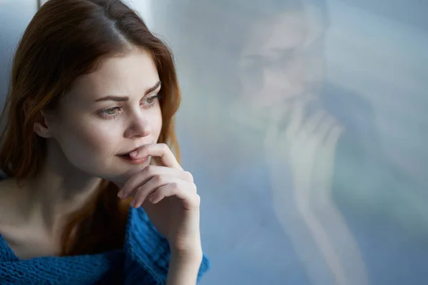 Kobieta siedzi w pobliżu okna z niebieską kratę reszta Styl życia — Zdjęcie stockowe