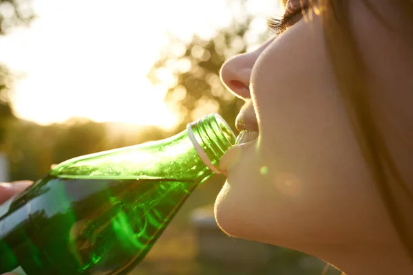 Mosolygó nő ivóvíz zöld palack frissítő szomjúság — Stock Fotó