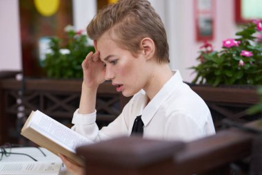 Elinde bir kitap olan öğrenci yaz tatilinde şehir içi iletişiminde.