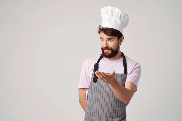 En man i förkläde med mössa på huvudet kock professionellt arbete — Stockfoto
