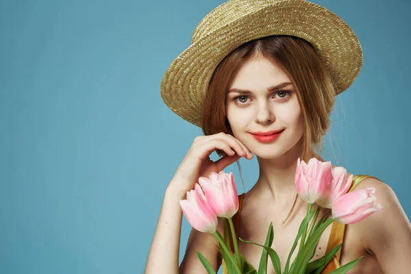 Mulher de chapéu com buquê de flores maquiagem charme decoração verão azul fundo — Fotografia de Stock