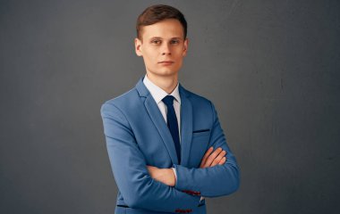 Takım elbiseli yakışıklı bir iş adamı iş yerinin önünde ellerini kavuşturdu.