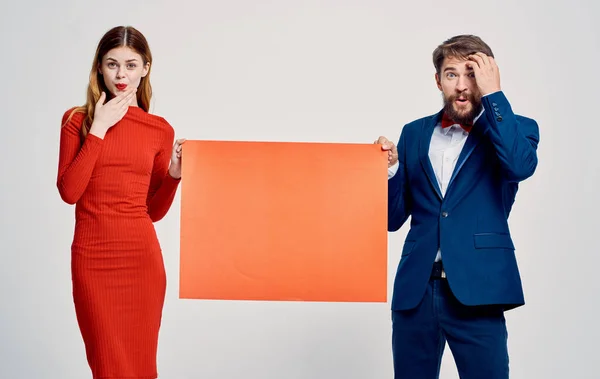Un homme en costume à côté d'une femme dans une robe rouge rabais publicitaire Espace de copie — Photo