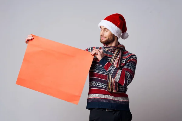 Hombre alegre en un sombrero de Navidad con fondo de luz cartel maqueta roja — Foto de Stock