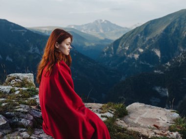 Dağlarda kırmızı ekoseli bir kadın açık havada temiz hava serin