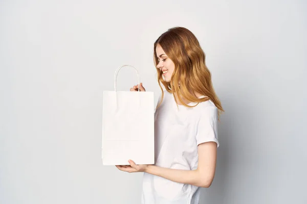 Woman make t-shirts with package in hands entertainment shopping — Stock Photo, Image