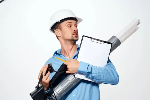 Um engenheiro em um capacete branco desenhos documentos profissionais trabalho — Fotografia de Stock