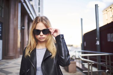 Dışarıda poz veren şık ceketli bir kadın.