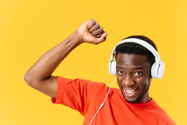 Homem alegre em fones de ouvido e gesticulando com as mãos dança música fundo amarelo — Fotografia de Stock