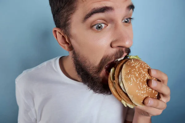 Homem barbudo com hambúrguer fast food close-up lifestyle — Fotografia de Stock