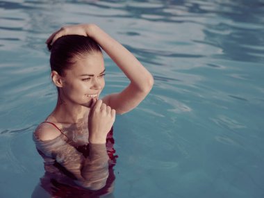 Havuzda yüzen çekici bir kadın. Bronzlaşma doğası lüksü.