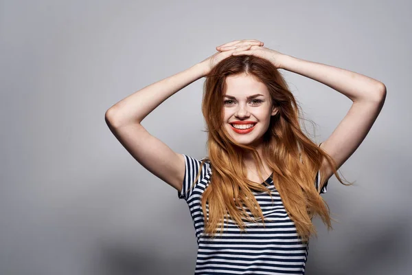 Mulher alegre segurando maquiagem cabelo posando divertido moda expressão luz fundo — Fotografia de Stock