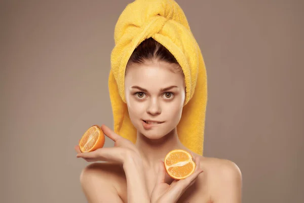 Mulher com uma toalha na cabeça com mandarina de frutas na mão vista cortada — Fotografia de Stock
