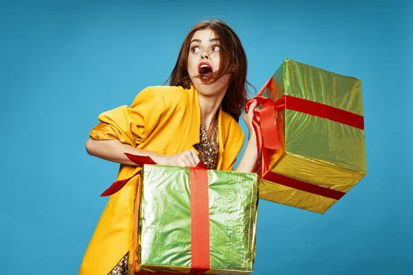 Frau mit Geschenkschachteln auf blauem Hintergrund mit weit geöffnetem Mund abgeschnittenes Modell — Stockfoto