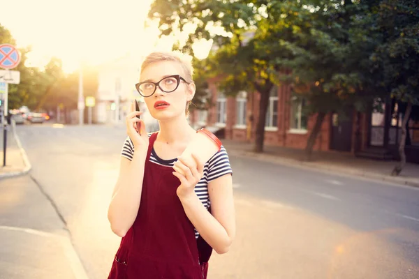 Vacker kvinna med glasögon på gatan pratar i telefon på sommaren — Stockfoto