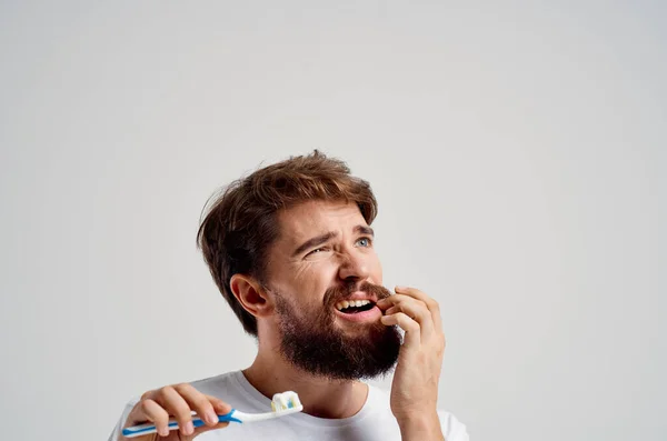 Muž Zubní Pastou Světlém Pozadí Kvalitní Fotografie — Stock fotografie