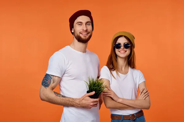 Homem engraçado e mulher em t-shirts roupas de juventude laranja fundo — Fotografia de Stock