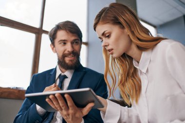 İş adamı ve kadın tablet teknoloji ofisiyle iletişim kuruyor.