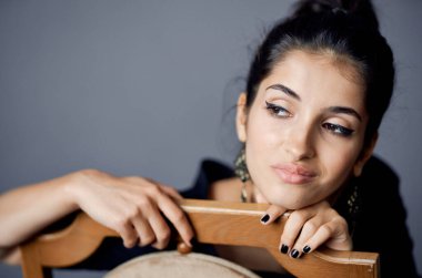 Sandalyenin yanındaki siyah elbiseli güzel kadın lüks moda yaşam tarzı stüdyosunun yanında.