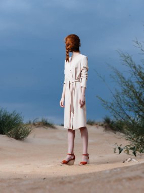 Kumsalda beyaz önlüklü bir kadın temiz hava veriyor.